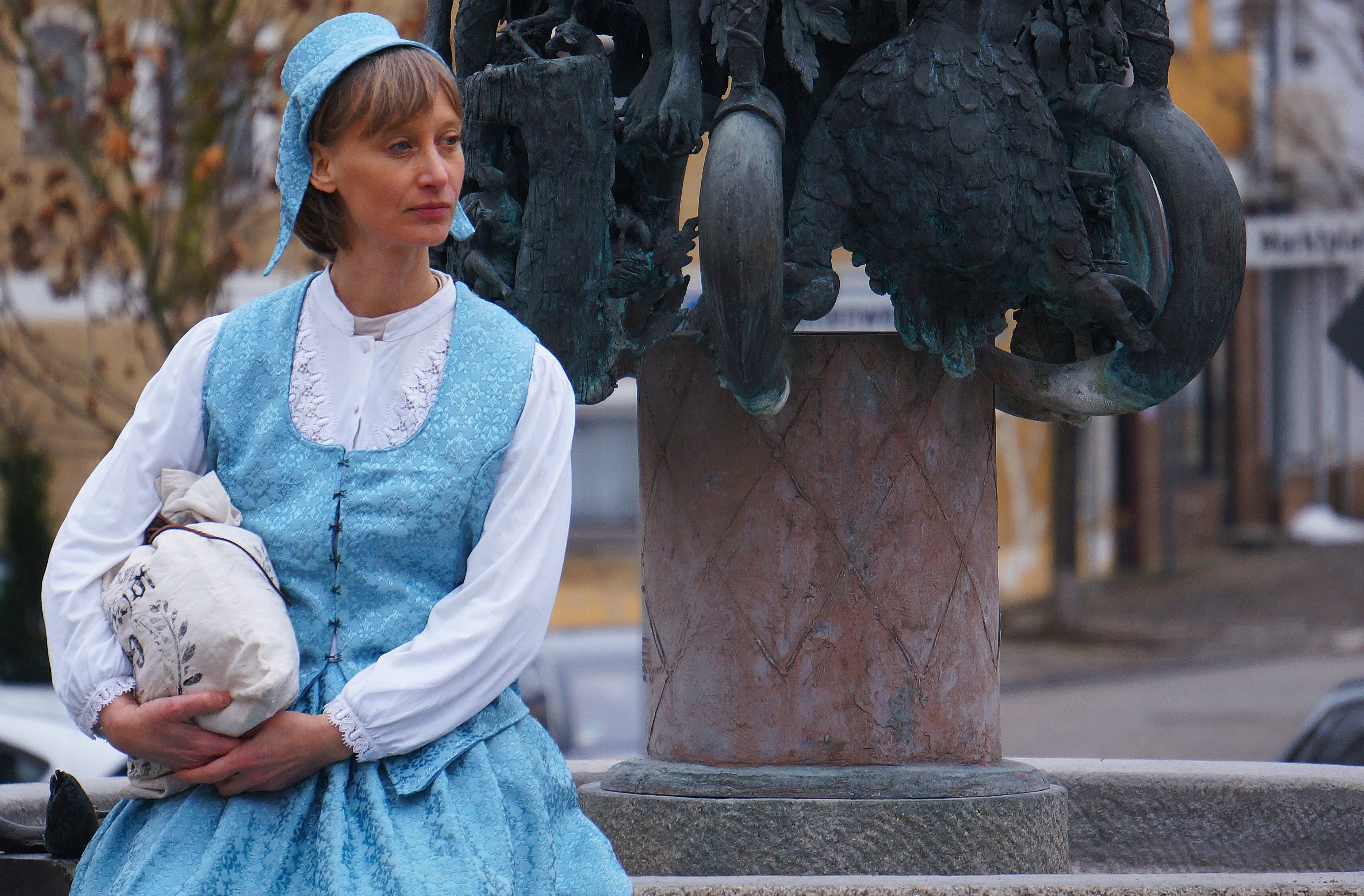 Lara erzählt Geschichte und Geschichten bei einer der Stationen, dem Regenstaufer Sagenbrunnen am Marktplatz.